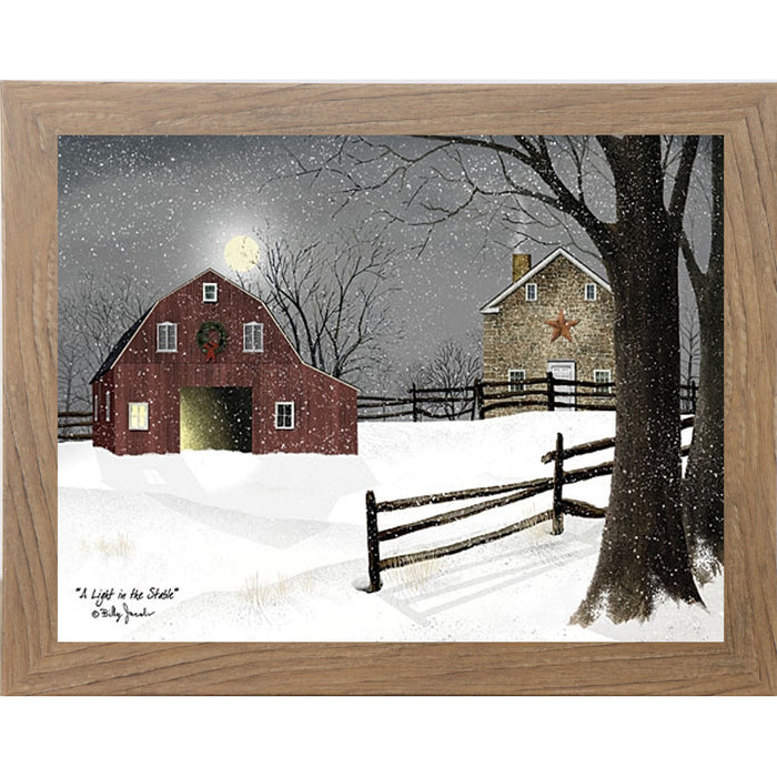 Farmtable framed landscape Billy Jacobs wall art print of a red barn with a Christmas wreath and glowing door on a moonlit snowy night with a stone farmhouse and split rail fence titled "A Light in the Stable"